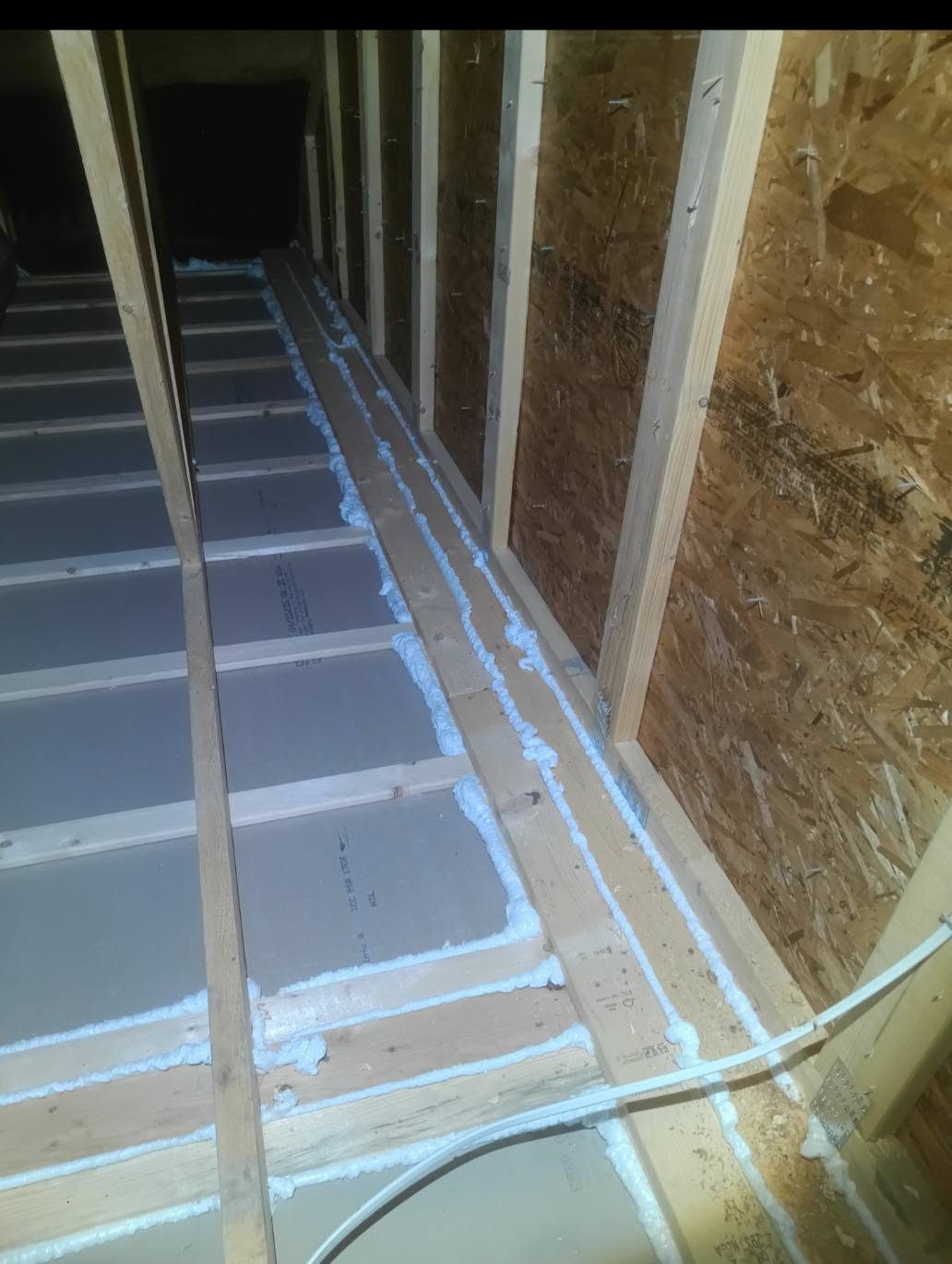 Foam air sealing along attic joists and top plates before insulation